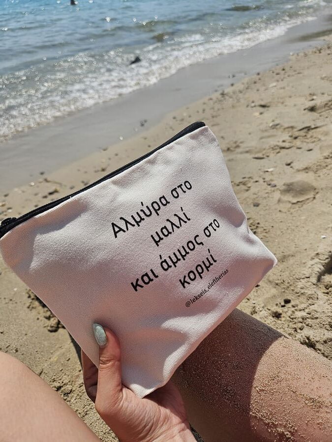Νεσεσέρ στην παραλία με την ελληνική φράση “Αλμύρα στο μαλλί και άμμος στο κορμί”